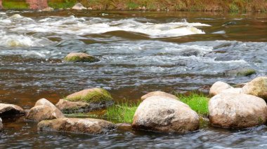 Bu güzel sahnede kayalar üzerinde bir nehir akar.
