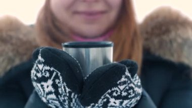 Kışın termostan sıcak çay tutan genç ve tatlı bir kadın..