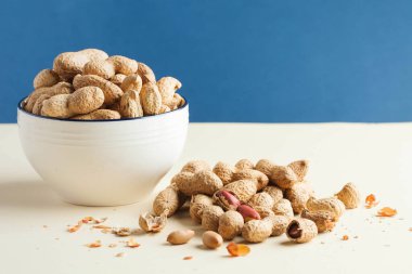 Kabuklarda ve kasede bir avuç fıstık. Sağlıklı beslenme, vejetaryenler için atıştırma, sebze yağları. Uzayı kopyala Yemek fotoğrafı..
