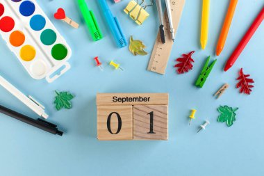 Mavi arka planda okul kırtasiyesi. Tahta takvim 1 Eylül. Bilgi günü konsepti. Yüksek kalite fotoğraf