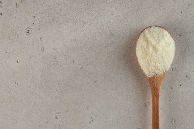 Collagen in the form of a white powder on a wooden spoon. Skin care, rejuvenation. Copy space. High quality photo clipart