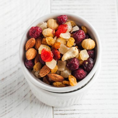 Beyaz ahşap bir masada fındık ve şekerli meyve karışımı. Sağlıklı çerez, sağlıklı tatlı. Yüksek kalite fotoğraf