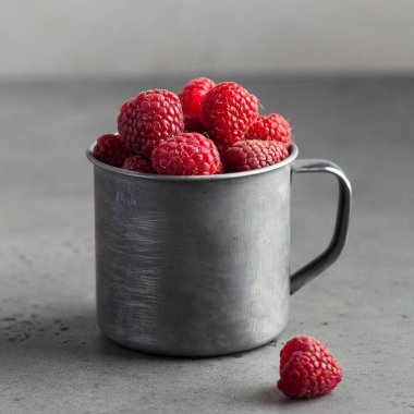 Gri arka planda ahşap bir kasede taze olgun ahududular. Sağlıklı beslenme kavramı. Uzayı kopyala Yüksek kalite fotoğraf