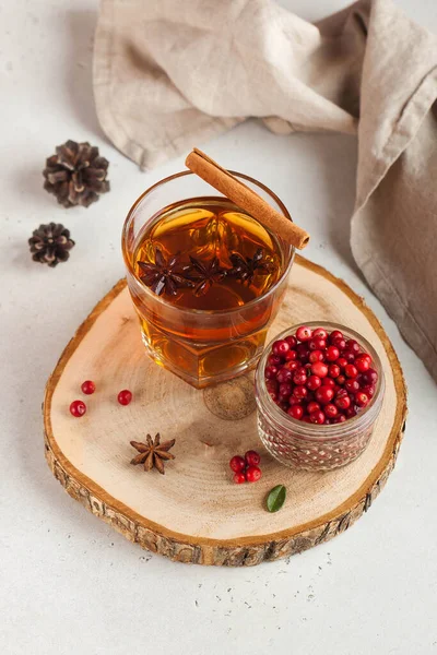 Hot teh dengan rempah-rempah, Apple dan berry dalam gelas transparan cangkir di stand kayu. Konsep kenyamanan rumah, musim gugur — Stok Foto