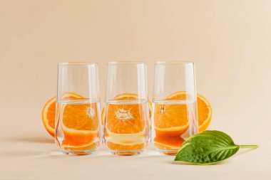 Bir bardak su için portakallar. Suyun çarpık görüntüsü. Sanat konsepti, trend fotoğraf. Minimalizm. Uzayı kopyala Yüksek kalite fotoğraf