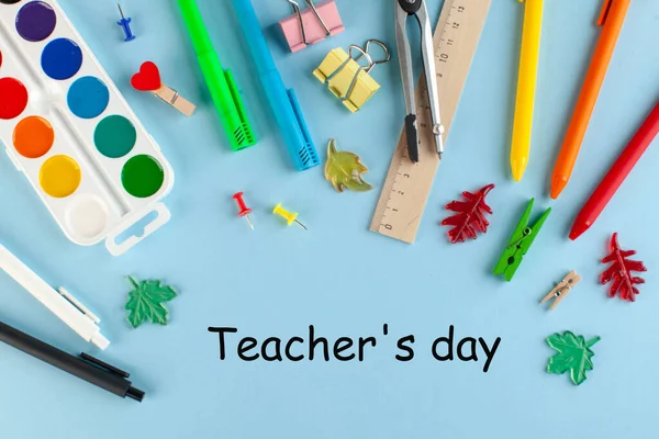 白色记事本 上面印有世界教师日的文字 周围是蓝色背景的学习用品 — 图库照片