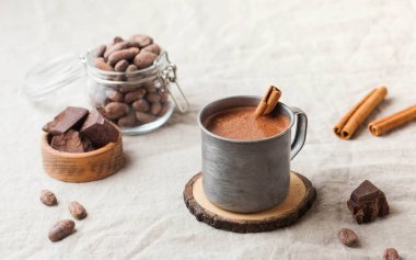 Masa örtüsünde tarçın çubuğu olan metal bardakta sıcak çikolata. Uzayı kopyala Yüksek kalite fotoğraf