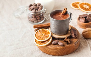 Masa örtüsünde tarçın çubuğu olan metal bardakta sıcak çikolata. Uzayı kopyala Yüksek kalite fotoğraf