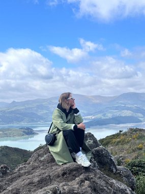 Bulutlu bir günde manzaralı dağ manzarasından hoşlanan bir kadın. Seyahat kavramı. Yeni Zelanda