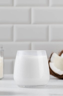 Dilimlenmiş hindistan cevizi arkaplanlı ve beyaz fayanslı taze hindistan cevizi sütü. Ücretsiz laktoz kavramı