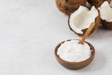 Tahta kaşık ve hindistan cevizli tahtadan bir kasede taze hindistan cevizli yoğurt. Vejetaryen yoğurt kavramı, laktozsuz. Boşluğu kopyala