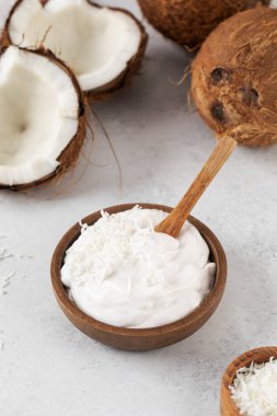 Tahta kaşık ve hindistan cevizli tahtadan bir kasede taze hindistan cevizli yoğurt. Vejetaryen yoğurt kavramı, laktozsuz..
