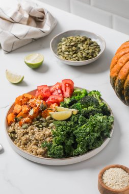 Besleyici bir yemek için kinoalı, balkabaklı ve sebzeli sağlıklı vegan Buda kasesi. Sebze tarifleri kavramı.