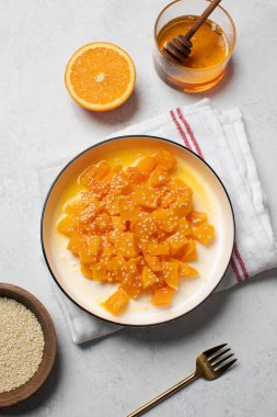 İçinde dilimlenmiş balkabağı, bal ve portakal suyu olan sağlıklı bir tatlı. Sağlıklı balkabağı yemeği konsepti.