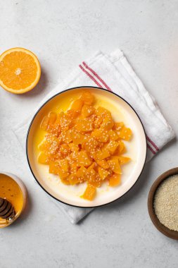 İçinde dilimlenmiş balkabağı, bal ve portakal suyu olan sağlıklı bir tatlı. Sağlıklı balkabağı yemeği konsepti.