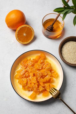 İçinde dilimlenmiş balkabağı, bal ve portakal suyu olan sağlıklı bir tatlı. Sağlıklı balkabağı yemeği konsepti.