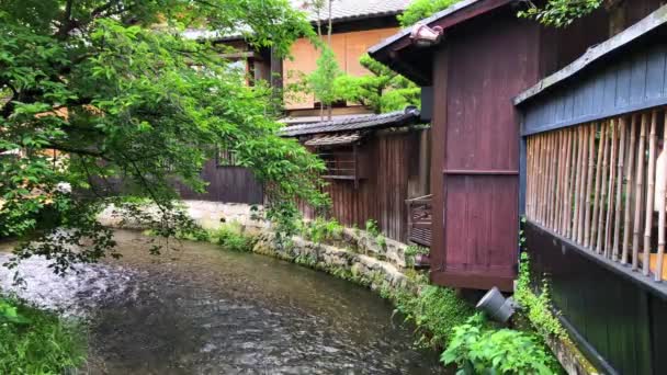 Rivière coulant devant les bâtiments japonais traditionnels . — Video