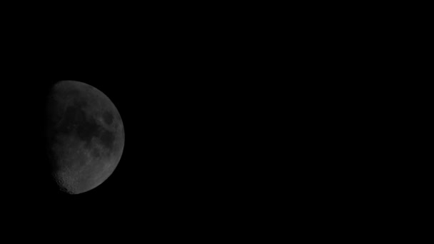 검은 색과 하얀색의 떠오르는 달이 구름 뒤에서 나타난다. . — 비디오