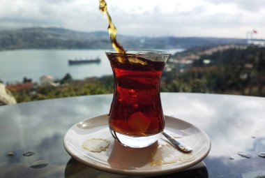 Istanbul, Türkiye'de meşhur Boğaz manzarasına sahip geleneksel çay bardağı şeker atarak. Siyah Tean ve şeker Bhosporus tarafından demlenmiş