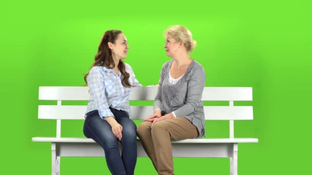 Őshonos, ölelés, ők ülnek egy fehér padon. Zöld képernyő — Stock videók