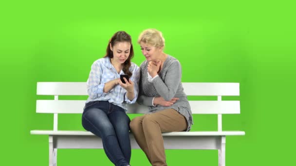 Flicka visar något i telefonen till sin mor. Grön skärm — Stockvideo