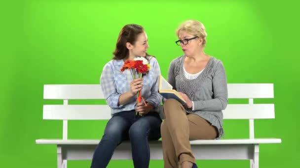 少女は、彼女の母親に花を与えます。緑色の画面 — ストック動画