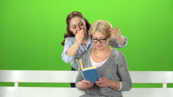 Frau sitzt auf einer Bank von hinten kommt Tochter und macht eine Überraschung. Green Screen — Stockvideo