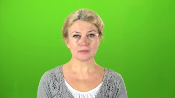 Actress with glasses raises her head and starts smiling . Green screen — Stock Video