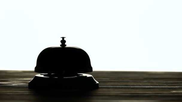 Hand presses the bell at the reception. White background. Silhouette — Stock Video