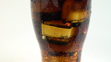 Gazlı İçecek bir bardak buz hisses ve baloncuklar içinde. Beyaz arka plan. Yakın çekim