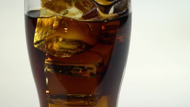 Soda in a glass with ice drink through a tube. White background. Ckose up — Stock Video