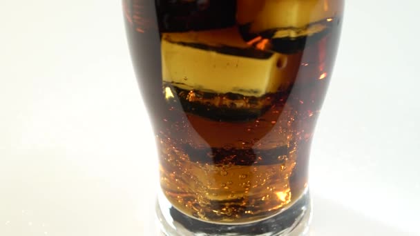 Kolsyrad dryck i ett glas med is. Vit bakgrund — Stockvideo