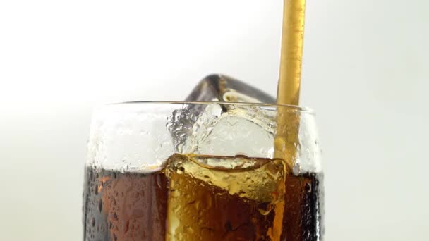 Soda in einem Glas mit Eisgetränk durch eine Röhre. weißer Hintergrund. Nahaufnahme — Stockvideo
