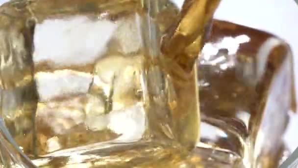 Coca Cola is gegoten in een glas ise. Witte achtergrond. Close-up. Slow motion — Stockvideo