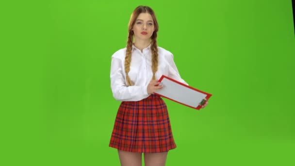 Girl raises a red tablet with paper. Green screen — Stock Video
