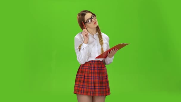 Colegiala con gafas escribe en papel blanco. Pantalla verde — Vídeos de Stock