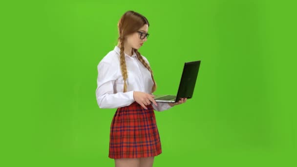 Student holds a laptop in her hands and prints on the keys. Green Screen — Stock Video
