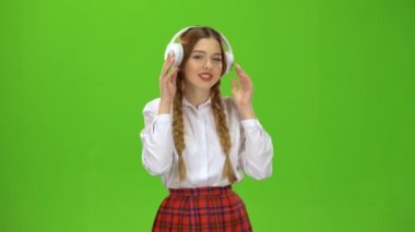 Kız kulaklıklar müzik dinler. Yeşil ekran