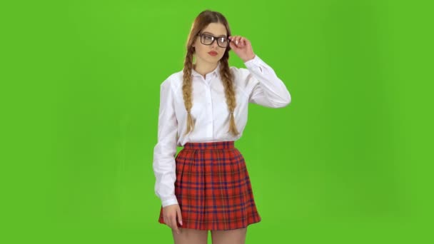 Школярка знімає окуляри і повії. Зелений екран — стокове відео