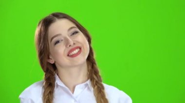 Kız gülümser ve kalp şekli gösterir. Yeşil ekran