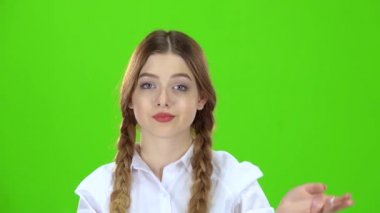 Kız beyaz bir bluz ve pigtails bir yumruk gösterir. Yeşil ekran