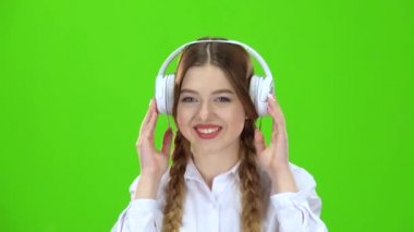Kız kulaklıklar müzik dinler. Yeşil ekran