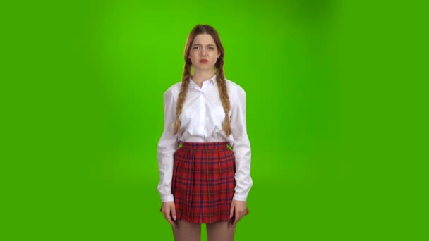 Φοιτητής σε μια λευκή μπλούζα και κοτσιδάκια δείχνει μια γροθιά. Πράσινη οθόνη — Αρχείο Βίντεο