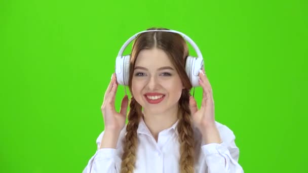 Chica escucha música en los auriculares. Pantalla verde — Vídeos de Stock