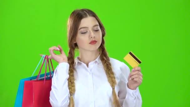 Εφηβικό κορίτσι με μια πιστωτική κάρτα και πακέτα στα χέρια της. Πράσινη οθόνη — Αρχείο Βίντεο