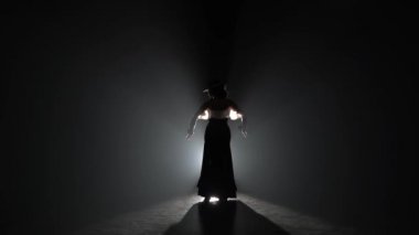 Kız dans onun elinde kastanyet içinde dans ediyor. Arkadan ışık. Duman arka plan