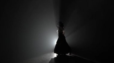 Kadın dans onun elinde kastanyet içinde dans ediyor. Arkadan ışık. Duman arka plan