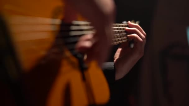 メンズの指は、アコースティック ギターの弦をタップします。クローズ アップ — ストック動画