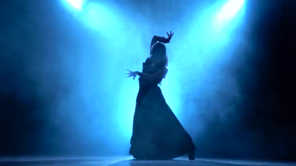 弗拉门戈。在黑暗的房间舞者用她的手做优雅的动作。从后面 Llight。烟雾背景。剪影 — 图库视频影像