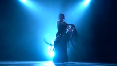 Flamenko. Kadın onun elinde bir manton ile dans ediyor. Arkadan llight. Duman arka plan. Siluet